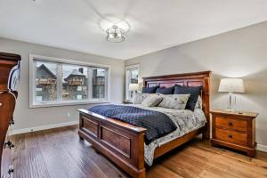 Un dormitorio con una cama grande y una ventana en Canmore Chalet with Hot tub at Three Sisters Mtn en Canmore