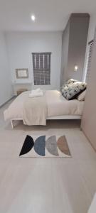a bedroom with a bed and a rug on the floor at Silver Oaks Luxury Guest Cottage in Langebaan