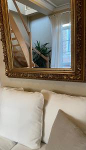 a mirror above a couch with a white pillow at Le 25, Duplex élégant au cœur du piétonnier historique in Namur