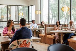 a group of people sitting at tables in a restaurant at The Woodlands Resort, Curio Collection by Hilton in The Woodlands
