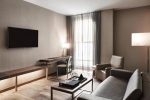 a hotel room with a couch and a tv at AC Hotel by Marriott New Orleans French Quarter in New Orleans