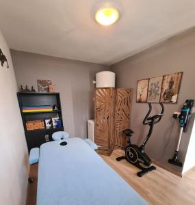 a bedroom with a bed and a exercise bike in it at Dépendance T3 in Aumes