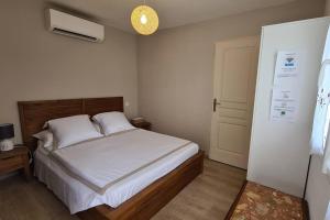 a bedroom with a white bed and a light at Dépendance T3 in Aumes