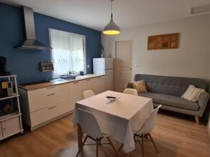 a kitchen and living room with a table and a couch at Dépendance T3 in Aumes