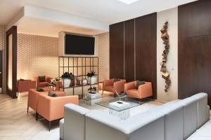a lobby with a waiting room with chairs and a tv at AC Hotel by Marriott New Orleans French Quarter in New Orleans