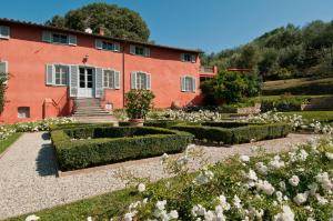 un jardin en face d'un bâtiment rouge dans l'établissement Villa Igea, à Mastiano