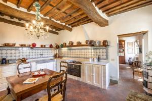 une cuisine avec une table en bois et un lustre dans l'établissement Villa Igea, à Mastiano