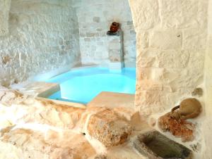 a large blue tub in a room with a stone wall at Trulli Ritunno Piccolo in Locorotondo
