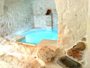a large blue tub in a room with a stone wall at Borgo San Francesco in Locorotondo