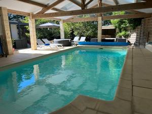 a swimming pool with a pergola and blue water at Le Clos des Lilas in Graves