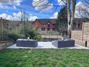 two concrete benches in a yard in front of a house at Riverside 3 Bed House in Winchester