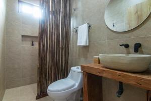 a bathroom with a sink and a toilet and a mirror at Hotel Boutique de playa - Casa Solhu in Santa Marta
