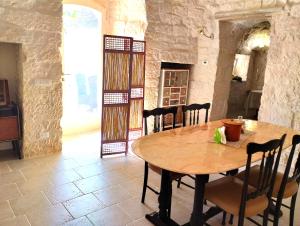 a dining room with a wooden table and chairs at Trulli Ritunno Piccolo in Locorotondo