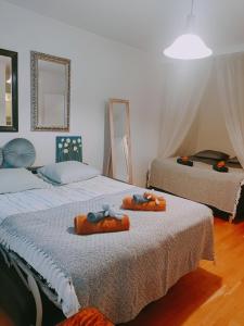 a bedroom with two beds with orange towels on them at Möysä beach apartment in Lahti
