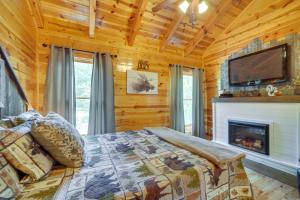 um quarto com uma cama com lareira e uma televisão em Family Cabin with Private Hot Tub and Game Room! em Sevierville