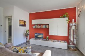 soggiorno con parete con accento rosso di Welcome Home Apartment a Lierna