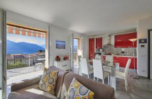 a living room with a couch and a kitchen with a view at Welcome Home Apartment in Lierna