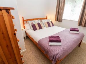 a bedroom with a bed with two towels on it at Brook Haven in Saint Cleer