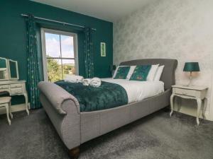a bedroom with a bed and a couch and a window at Gweek House in Helston