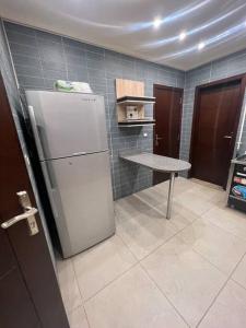 a kitchen with a white refrigerator and a table at دوبلكس بيفرلي هيلز اربع غرف الشيخ زايد فرش مودرن in Sheikh Zayed