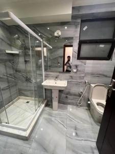 a bathroom with a shower and a sink and a toilet at دوبلكس بيفرلي هيلز اربع غرف الشيخ زايد فرش مودرن in Sheikh Zayed