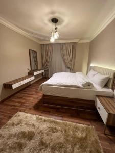 a bedroom with a large white bed and a rug at دوبلكس بيفرلي هيلز اربع غرف الشيخ زايد فرش مودرن in Sheikh Zayed