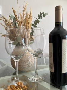 uma garrafa de vinho e dois copos de vinho numa mesa em Pellegrini Apartment Mendoza em Mendoza