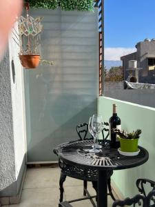 a table on a balcony with a glass of wine at Pellegrini Apartments Mendoza !! Estupendos Departamentos con Cochera Privada cercanos a Parque Gral San Martin in Mendoza