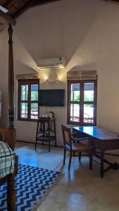 een kamer met een tafel, een stoel en ramen bij Thanga House by LuxUnlock Private Villas in Tarangambādi