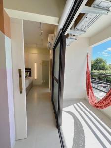 a room with a balcony with a hammock in it at PALMAS EXPERIENCE - Apartamento Girassol in Palmas