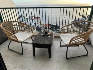 - un balcon avec deux chaises et une table avec des verres à vin dans l'établissement Gigantes View Studio, à Puerto de Santiago
