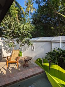 een patio met een stoel en een tafel naast een zwembad bij Thanga House by LuxUnlock Private Villas in Tarangambādi