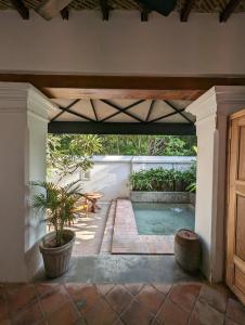 een open patio met een zwembad en een tafel bij Thanga House by LuxUnlock Private Villas in Tarangambādi