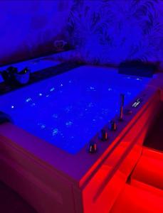 bañera en una habitación con luces azules y rojas en Glamour suite, en Gravina in Puglia