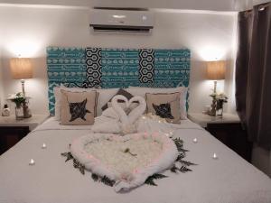 a bed with a heart shaped pillow on it at Bella Vista Resort Belize in San Pedro