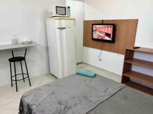 a room with a refrigerator and a tv on the wall at Studio em São Paulo - Expo Center Norte in São Paulo