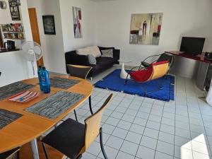 uma sala de estar com uma mesa e cadeiras e um sofá em Komfortables 3-Zimmer Apartment in Schwetzingen zwischen Mannheim und Heidelberg em Schwetzingen