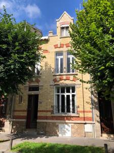 un vecchio edificio in mattoni con una grande finestra sopra di Maison et jardin à Epernay centre ville a Épernay