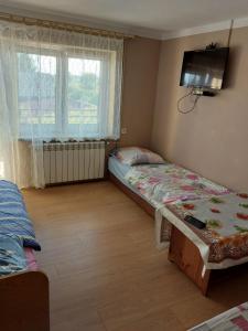 a bedroom with two beds and a tv on the wall at Morfeusz in Zamość