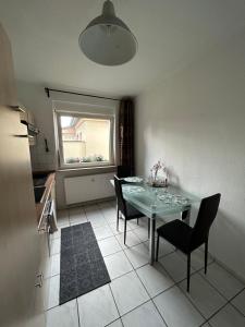 uma cozinha com mesa e cadeiras e uma janela em Gemütlich eingerichtete 2-Zimmer Wohnung in Duisburg Meiderich em Duisburg