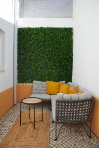 a living room with a couch and a green wall at My Lisbon Home Castelo in Lisbon