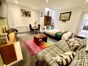 a living room with a couch and a bed at Executive apartments, nr city centre with private parking in Plymouth