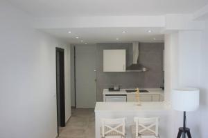 eine Küche mit einer weißen Insel in einem Zimmer in der Unterkunft Apartamento primera línea de mar in Platja  d'Aro