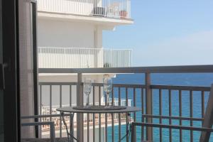 a balcony with a table with two wine glasses on it at Apartamento primera línea de mar in Platja  d'Aro