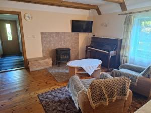 een woonkamer met een tafel en een piano bij Brīviņi in Jaunjelgava