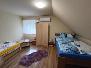 niewielka sypialnia z 2 łóżkami i oknem w obiekcie Holt-Tisza Vendégház w Segedynie