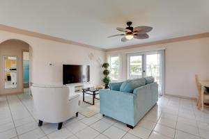 uma sala de estar com um sofá azul e uma televisão em Pet-Friendly Port Charlotte Home with Canal Access! em Port Charlotte