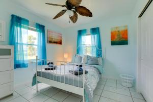 een blauwe slaapkamer met een bed en een plafondventilator bij Pet-Friendly Port Charlotte Home with Canal Access! in Port Charlotte