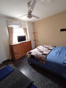 a bedroom with a bed and a dresser and a window at Como en casa Hostel in Posadas