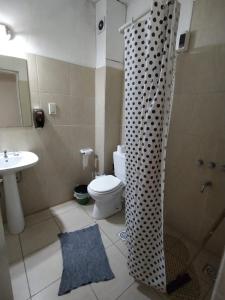 een badkamer met een toilet, een wastafel en een douche bij Como en casa Hostel in Posadas